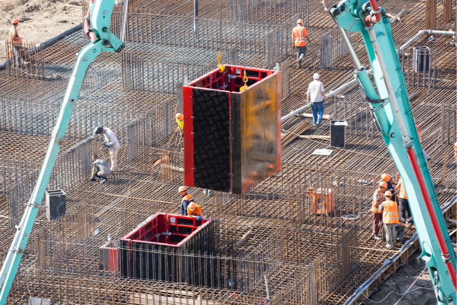 A construction crane positioning a steel structure onto the skeleton of a new high-rise building.